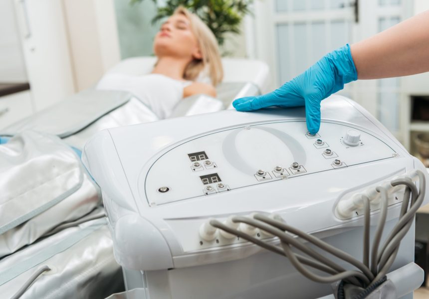 Cropped,View,Of,Cosmetologist,Setting,Up,Machine,For,Pressotherapy